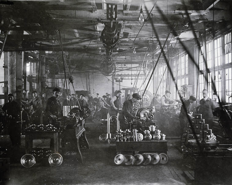 Men work with machines on a factory floor.