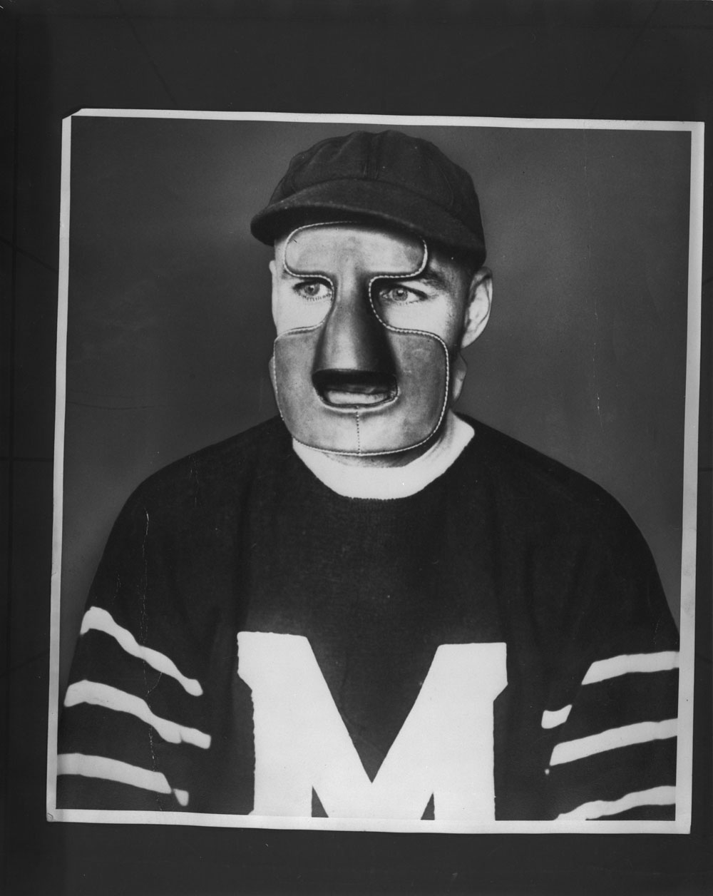 Man wearing a hockey jersey and a mask that covers his forehead, nose, chin, and lower cheeks.