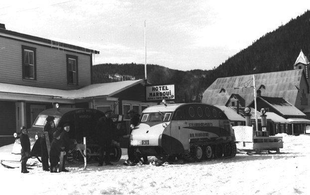 Vehicles with rubber track tires, surrounded by snow.