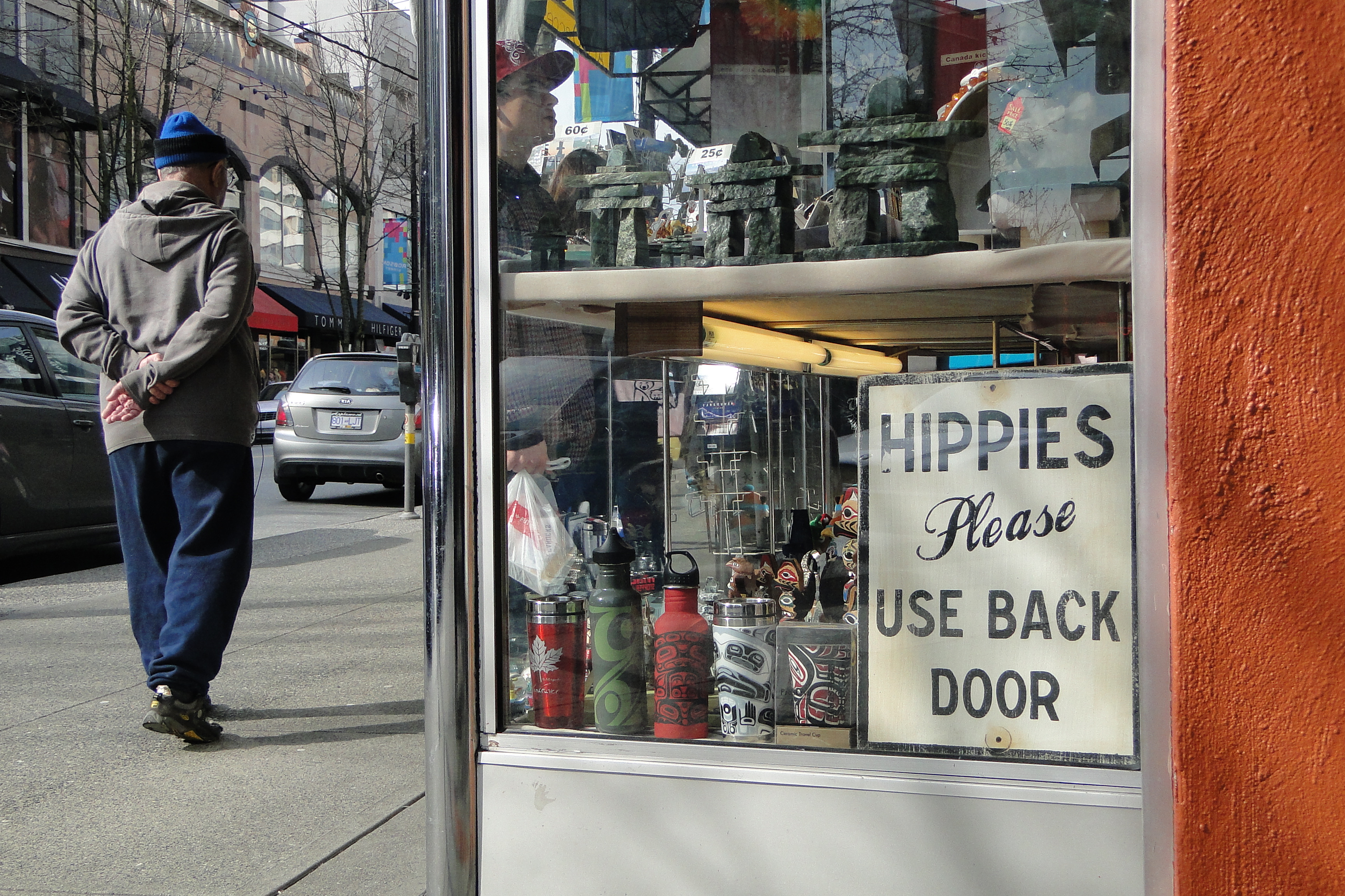 A sign in a storefront says "Hippies please use back door."