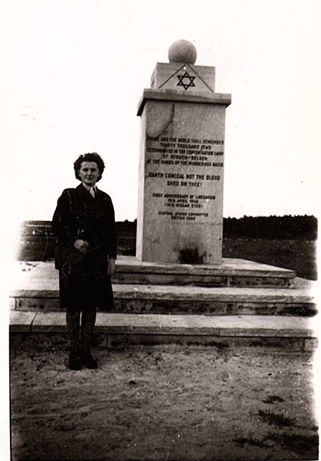 A woman stands by a monument. Long description available.