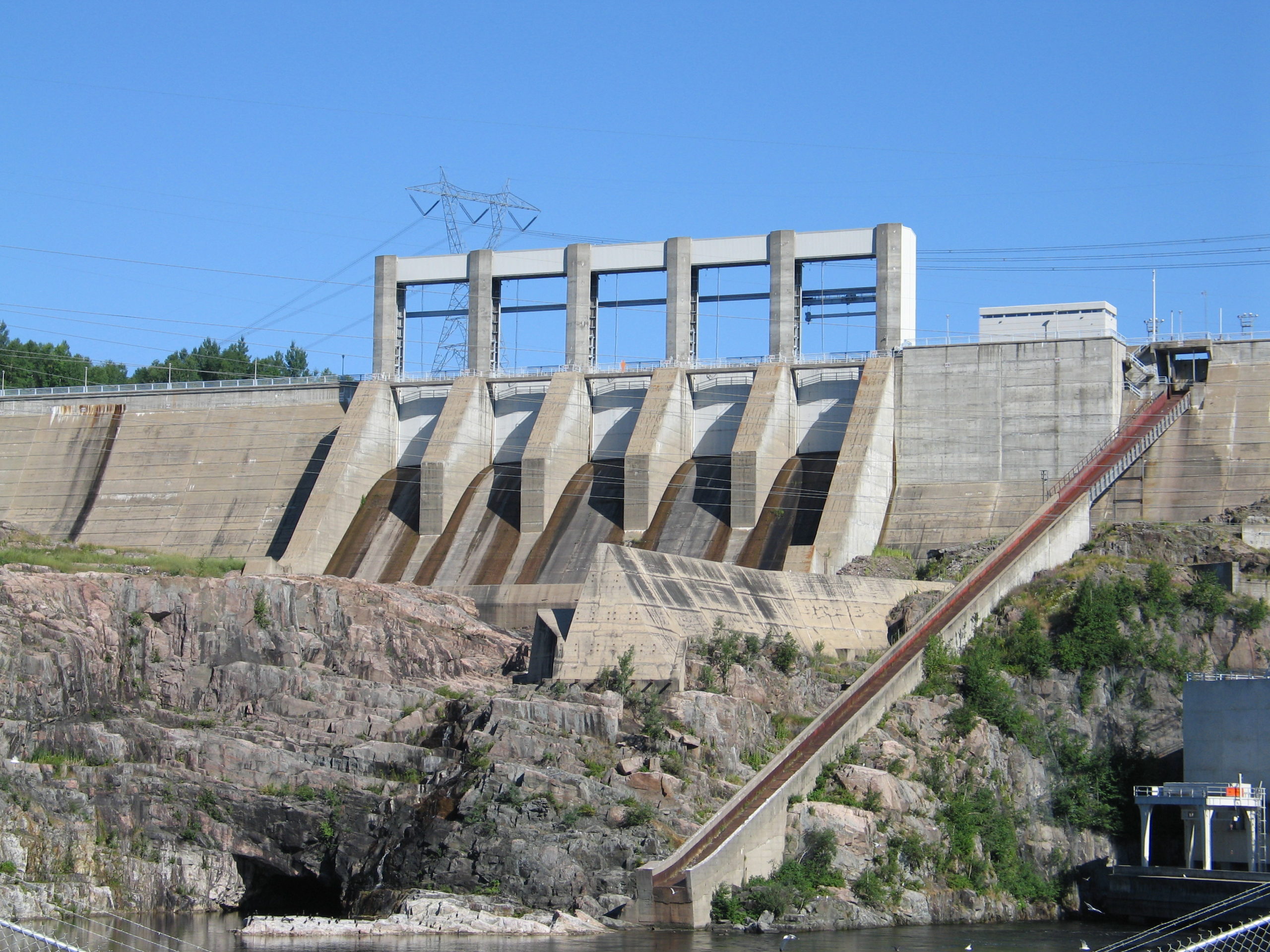 A concrete generating station sits above a river.