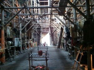 A long, tall building with logs used as support beams