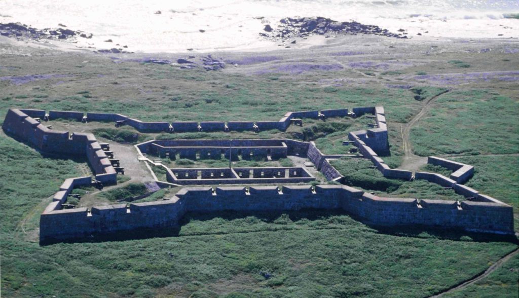 A stone fort shaped like a four-pointed star. Within the fort is a square pit with stone walls.
