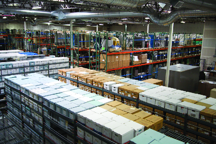 Photo of a factory floor, showing stacks of boxes.