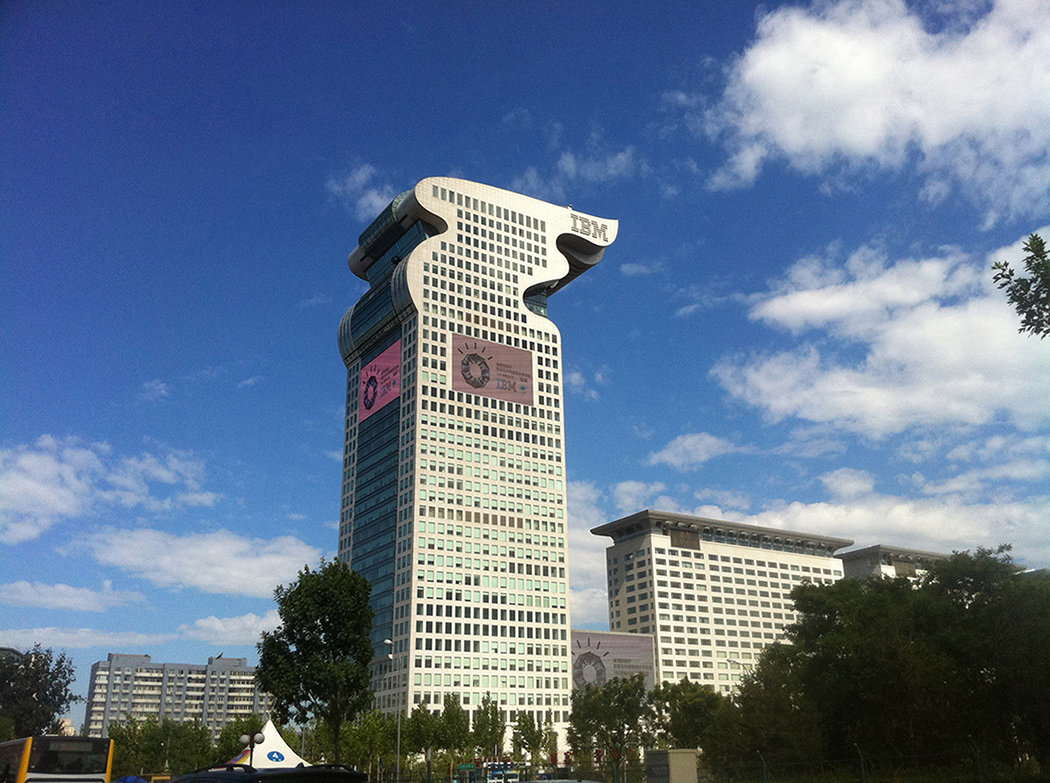 A photo shows a view of the Dragon Building, I B M’s headquarters based in China, against a clear blue sky.