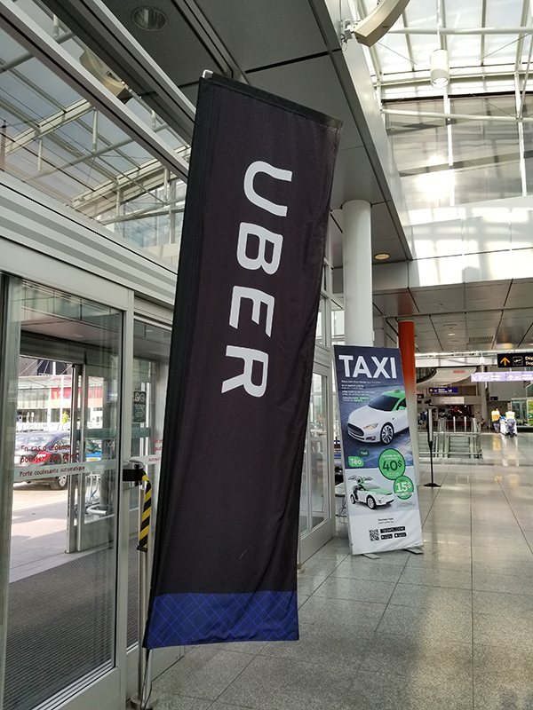 A photo shows an Uber sign indicating Uber’s pickup spot at Pierre Elliott Trudeau Airport in Montreal.