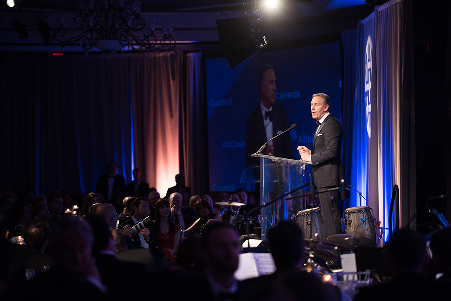 A photo shows Howard Schultz delivering a speech after receiving Distinguished Business Leadership Award.
