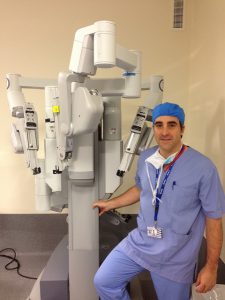 A surgeon standing next to the da Vinci robot.