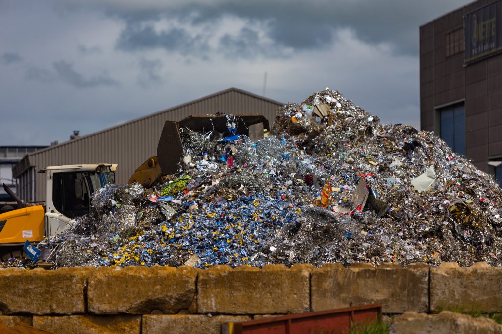 A giant pile of recycling outside of a recycling centre.