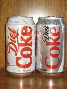 An old Diet Coke can next to a new one.