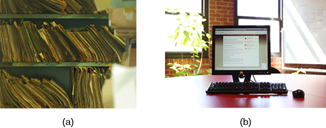 (a) A photograph shows stacks of paper files on shelves. (b) A photograph shows a computer on a desk.