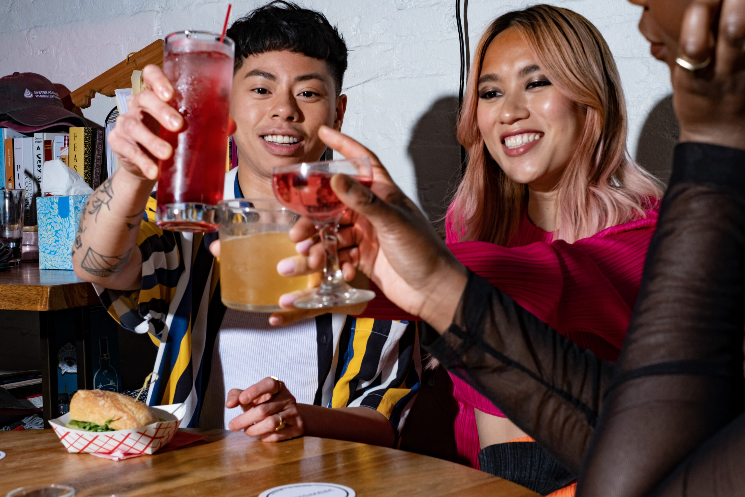 A group of friends of varying genders making a toast with alcohol. 