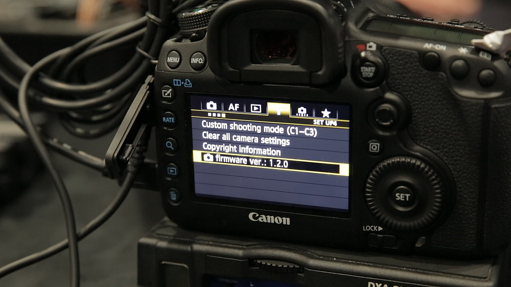 A digital camera interface shows a message about a firmware update.