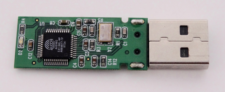 This is a photograph of a PCB with an IC and various other components on it. The PCB is attached to a USB connector. Labels for all components are printed on the board.